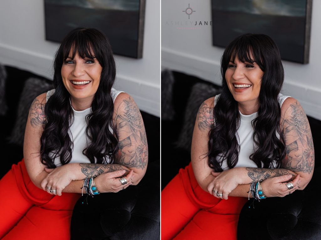 Beautiful tattooed model and photographer with long dark and wearing red pants and a white tank top.