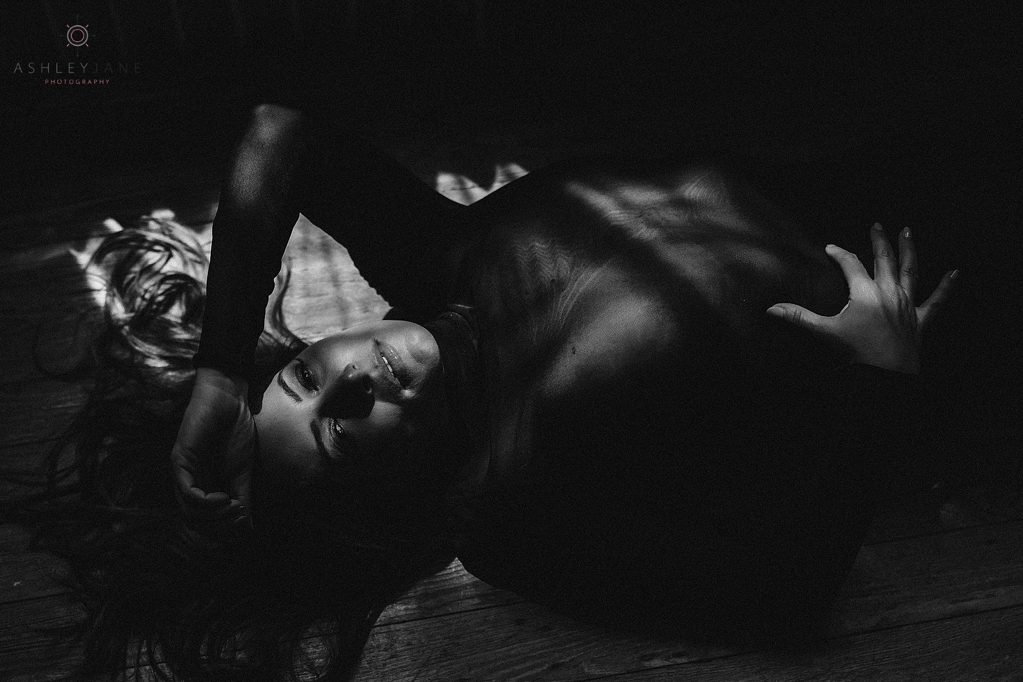 rtistic boudoir portrait featuring dramatic shadows and soft natural light.